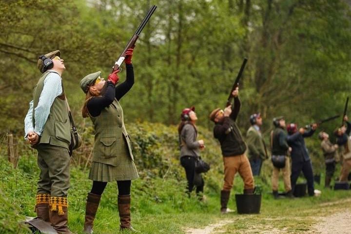 People shooting shotguns outdoors