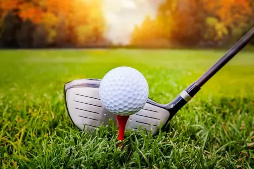 Golf ball on tee with club