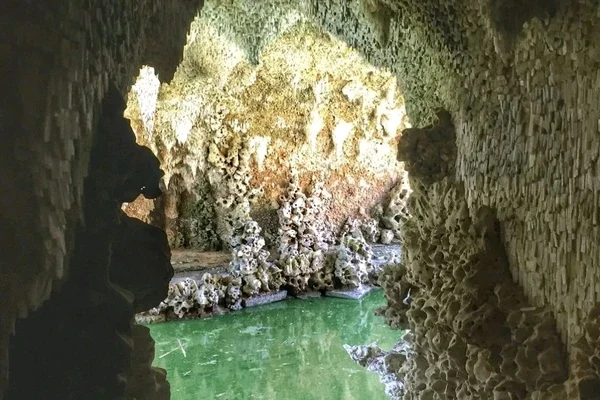 Cave entrance with green water